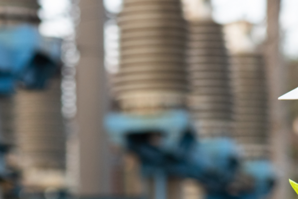 Utility worker in front of transmission station
